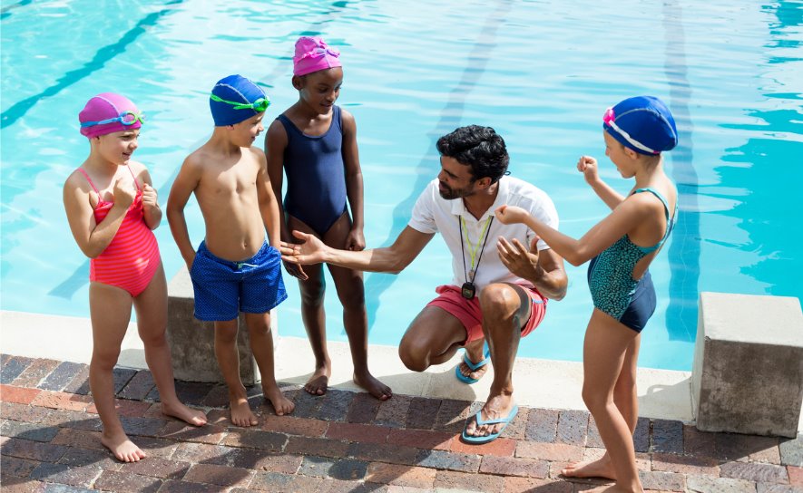 Age Group Swimmers on Deck with Coach