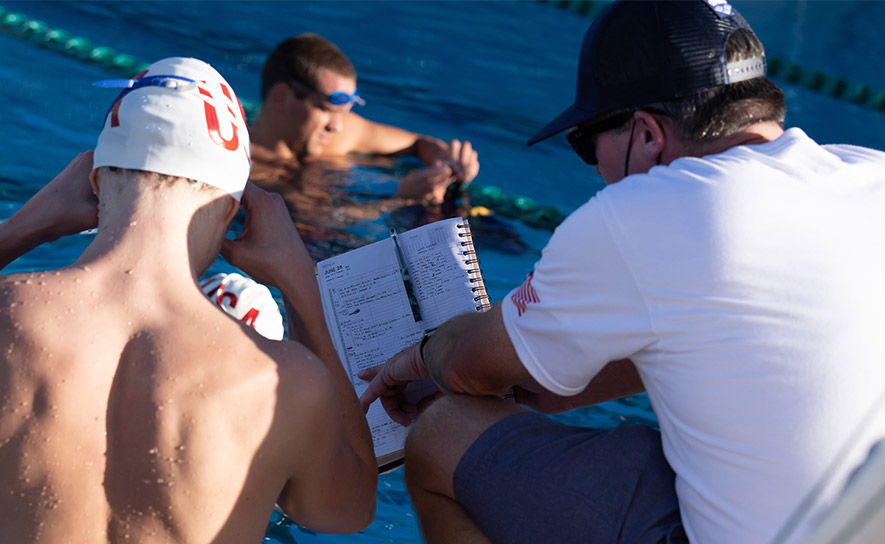 Coach and Swimmer with Training Schedule