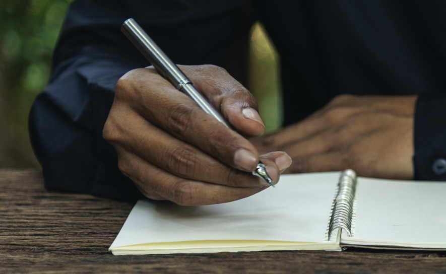 Guy Writing in Notebook