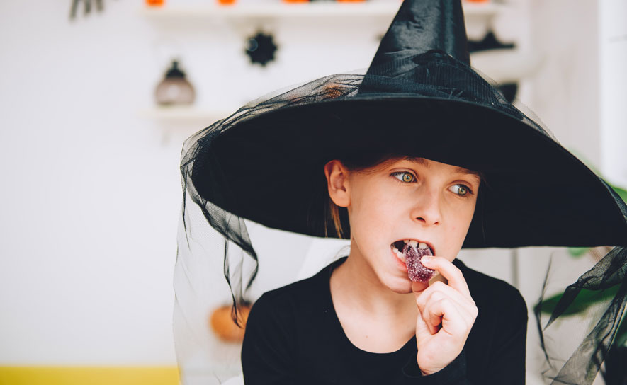 Girl in Halloween Costume Eating Candy